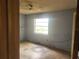 Bedroom with blue walls, one window, ceiling fan, laminate floors awaiting renovation at 2810 Kumquat Dr, Edgewater, FL 32141