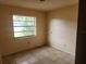 Small bedroom with window, neutral colored walls and tile floors, awaiting renovation at 2810 Kumquat Dr, Edgewater, FL 32141