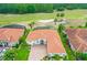 Aerial view of home with brick driveway and landscaping. Golf course in background with mature trees at 2814 S Asciano Ct, New Smyrna Beach, FL 32168