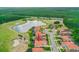 Aerial view of home with tile roof, a pond, and a golf course view. Arrow points to property at 2814 S Asciano Ct, New Smyrna Beach, FL 32168