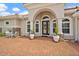 Inviting front entrance with stucco pillars, arched doorway, brick driveway and desert landscaping at 2814 S Asciano Ct, New Smyrna Beach, FL 32168