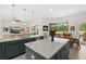 Open-concept kitchen featuring gray cabinets, an island with seating, and a view of the dining area at 2814 S Asciano Ct, New Smyrna Beach, FL 32168