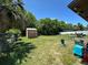 Well-maintained backyard with a wooden shed, patio set, and green lawn at 2816 Travelers Palm Dr, Edgewater, FL 32141