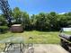 Spacious backyard featuring lush greenery, a grill, outdoor table and chairs, and a shed at 2816 Travelers Palm Dr, Edgewater, FL 32141