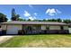 Charming single-story home featuring a brick accent, a lush green lawn and mature landscaping at 2816 Travelers Palm Dr, Edgewater, FL 32141