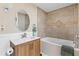 Elegant bathroom with a soaking tub, tiled walls, and a wood vanity at 2824 Oak Lea Dr, South Daytona, FL 32119