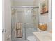 Cozy bathroom featuring a shower with glass doors and tiled walls at 2824 Oak Lea Dr, South Daytona, FL 32119