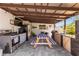 This outdoor kitchen features stainless steel appliances and wooden picnic table at 2824 Oak Lea Dr, South Daytona, FL 32119