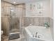 Elegant bathroom featuring a glass-enclosed shower and a soaking tub perfect for relaxation and rejuvenation at 3 Riverwalk Dr # 202, New Smyrna Beach, FL 32169