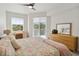 Bright bedroom with a large window, balcony access, dresser, desk, and cozy decor for relaxation at 3 Riverwalk Dr # 202, New Smyrna Beach, FL 32169