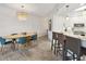 Beautiful dining area with a modern light fixture, a wooden table with seating for six, and wood look tile floors at 3 Riverwalk Dr # 202, New Smyrna Beach, FL 32169