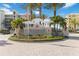 Community entrance sign surrounded by palm trees and beautiful landscaping at 3 Riverwalk Dr # 202, New Smyrna Beach, FL 32169