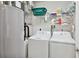 Practical laundry room with washer, dryer, water heater, and shelving for storage at 3 Riverwalk Dr # 202, New Smyrna Beach, FL 32169