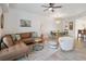 Open-concept living room with modern furnishings, a ceiling fan, and access to the dining area and kitchen at 3 Riverwalk Dr # 202, New Smyrna Beach, FL 32169