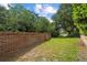 Beautiful backyard with a brick fence, green lawn and mature trees, providing a peaceful outdoor retreat at 30 Reflections Village Dr, Ormond Beach, FL 32174