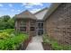 Charming brick home exterior featuring manicured landscaping and a sheltered entryway at 30 Reflections Village Dr, Ormond Beach, FL 32174