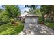Charming brick home featuring a well-maintained lawn, mature landscaping, and an attached two-car garage at 30 Reflections Village Dr, Ormond Beach, FL 32174