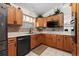 Kitchen featuring wood cabinets, black appliances, tile floors, and backsplash at 30 Reflections Village Dr, Ormond Beach, FL 32174