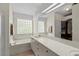 Main bathroom features a tub with tile surround, large mirror, and vanity with sink at 30 Reflections Village Dr, Ormond Beach, FL 32174