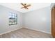 Cozy bedroom with wood-look flooring, a ceiling fan, and a window providing natural light at 3107 Mapleshade St, Deltona, FL 32738
