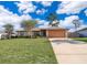 Charming single-story home boasts a large front yard, long driveway, and attached two-car garage at 3107 Mapleshade St, Deltona, FL 32738