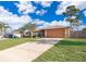 Charming single-story home boasts a large front yard, long driveway, and attached two-car garage at 3107 Mapleshade St, Deltona, FL 32738