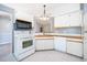 Functional kitchen with white appliances, tiled floors, and ample cabinet space at 3107 Mapleshade St, Deltona, FL 32738