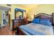 Bedroom with wooden floors, yellow walls, and a large dresser with a decorative mirror at 313 Dirksen Dr # A5, Debary, FL 32713