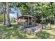 Charming wooden gazebo featuring an American flag, a picnic table and surrounded by trees at 313 Dirksen Dr # B15, Debary, FL 32713