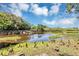 Scenic view of a pond with a wooden bridge, lush trees, and a cloudy sky at 313 Dirksen Dr # B15, Debary, FL 32713