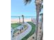 Lush garden pathway leading to the beach, bordered by palm trees and manicured greenery for a serene ambiance at 3311 S Atlantic Ave # 604, Daytona Beach Shores, FL 32118
