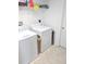 Functional laundry room with washer, dryer, shelving, and ample space for laundry tasks at 3311 S Atlantic Ave # 604, Daytona Beach Shores, FL 32118