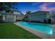 Beautiful backyard pool with adjacent patio and lawn, surrounded by lush landscaping and the home's exterior at 3698 Lower Park Rd, Orlando, FL 32814