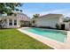 Beautiful backyard pool with adjacent patio and lawn, surrounded by lush landscaping and the home's exterior at 3698 Lower Park Rd, Orlando, FL 32814