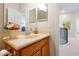 Bathroom with a tan single sink vanity, framed mirror, and doorway to the hall at 3698 Lower Park Rd, Orlando, FL 32814