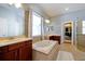 Luxurious bathroom with a soaking tub, double vanity, and a walk-in closet at 3698 Lower Park Rd, Orlando, FL 32814