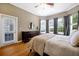 Serene bedroom boasts hardwood floors, a dresser, and plenty of natural light from multiple windows at 3698 Lower Park Rd, Orlando, FL 32814
