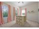 Sunlit bedroom with pink tassel curtains, craft table with storage, and neutral walls at 3698 Lower Park Rd, Orlando, FL 32814