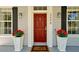 Inviting front door with sidelights, a welcome mat, and matching planters filled with colorful flowers at 3698 Lower Park Rd, Orlando, FL 32814