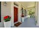 Front porch with sidelight windows, a welcome mat, and matching planters filled with colorful flowers at 3698 Lower Park Rd, Orlando, FL 32814