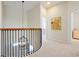 Upstairs hallway featuring a black iron railing and modern chandelier at 3698 Lower Park Rd, Orlando, FL 32814