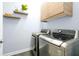 Modern laundry room featuring stainless steel appliances, floating shelves, and ample storage at 3698 Lower Park Rd, Orlando, FL 32814