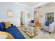 Bright living room showcasing a stylish blue sofa, glass coffee table, and elegant decor with hardwood flooring at 3698 Lower Park Rd, Orlando, FL 32814