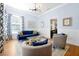 Comfortable living room featuring a plush blue sofa, modern lighting fixture, and tasteful decor throughout at 3698 Lower Park Rd, Orlando, FL 32814