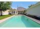 Backyard view of a refreshing in-ground pool surrounded by lush landscaping, perfect for relaxing and outdoor entertainment at 3698 Lower Park Rd, Orlando, FL 32814