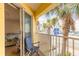 Balcony view of street, palm trees, and neighboring buildings and a chair at 3733 Cardinal Blvd # 1, Daytona Beach, FL 32118