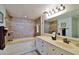 This bathroom features a built-in bathtub with shower, vanity, and decorative elements at 3855 S Atlantic Ave # 1405, Daytona Beach, FL 32118