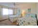 Inviting bedroom with two beds decorated in a stylish, coastal theme and a ceiling fan at 3855 S Atlantic Ave # 1405, Daytona Beach, FL 32118
