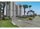 Condo entrance with a security gate, lush landscaping, and access to parking at 3855 S Atlantic Ave # 1405, Daytona Beach, FL 32118