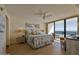 Main bedroom showcasing a ceiling fan, large windows with ocean view, and decorative painting at 3855 S Atlantic Ave # 1405, Daytona Beach, FL 32118